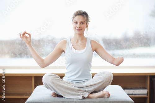 Photo: Young woman with amputee arm in yoga pose Young woman with amputee arm in yoga pose