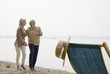 A senior couple walking beside a lake laughing