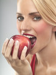 A woman eating a red apple