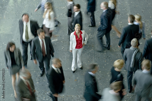 Photo: A woman standing in a crowd of businesspeople A woman standing in a crowd of businesspeople