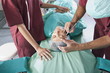 Surgeon marking incision lines on face in operating room