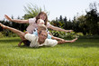 Family playing airplane on grass