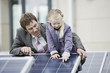 A businessman showing a solar panel to a young girl