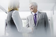 A businessman and businesswoman shaking hands