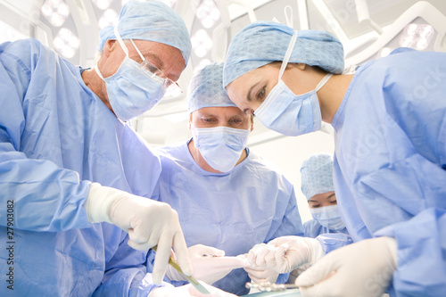 Photo: Surgeons performing operation in hospital operating room Surgeons performing operation in hospital operating room
