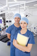 Surgeons standing with medical chart in hospital operating room