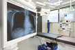 Surgeon standing in hospital operating room with x-ray and equipment