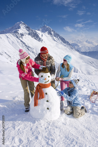 Photo: Family building snowman together Family building snowman together