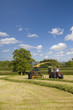 Tractor loading silage into truck in farm field