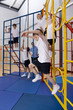 School children climbing gymnasium climbing equipment