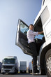 Truck driver climbing in to cab of semi-truck