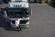 Truck driver standing near semi-truck on loading dock