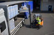 Worker driving forklift loading inventory on semi-truck on loading dock