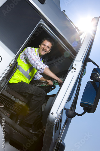 Photo: Truck driver closing door of semi-truck Truck driver closing door of semi-truck