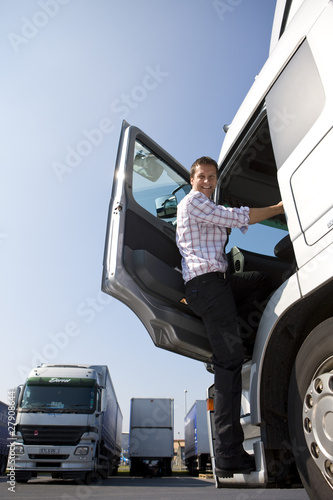 Photo: Truck driver climbing in to cab of semi-truck Truck driver climbing in to cab of semi-truck