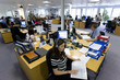Sales people working at desks in call center office