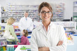 Pharmacist in pharmacy with customers in background