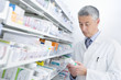 Pharmacist reading medicine bottle in pharmacy
