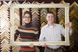 Clerks lifting gold frame in frame shop