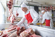 Smiling butcher arranging meat in display case