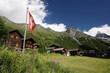 Swiss flag flies above the town of Gruben in Switzerland Swiss flag flies above the town of Gruben in Switzerland