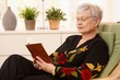 Pensioner reading in armchair