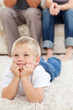 Cute little boy lying on the floor and watching television with