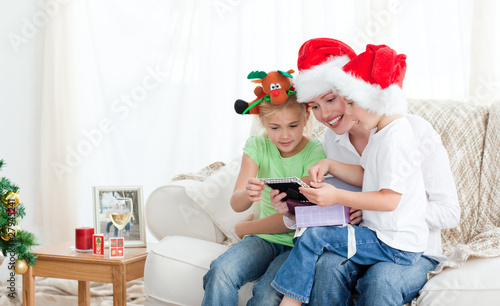 Photo: Mother and children looking at a calendar sitting on the sofa Mother and children looking at a calendar sitting on the sofa