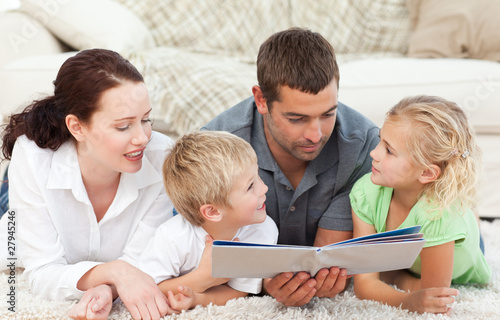 Photo: Cute family reading a children's book Cute family reading a children's book