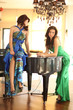 Two beautiful young women at a piano