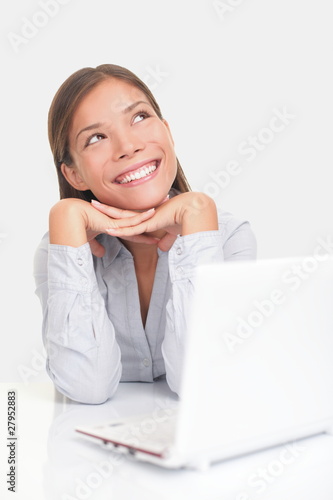 Photo: Happy woman thinking with computer Happy woman thinking with computer