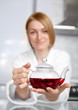 woman drinking tea (focus of the teapot)