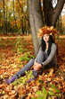 brunette is sitting near tree at the autumn forest brunette is sitting near tree at the autumn forest