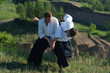 Two young man are training in Aikido in wood