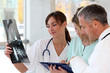 Foto: Medical team with handicapped person looking at X-ray Medical team with handicapped person looking at X-ray