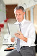 Office worker looking at internet on electronic pad