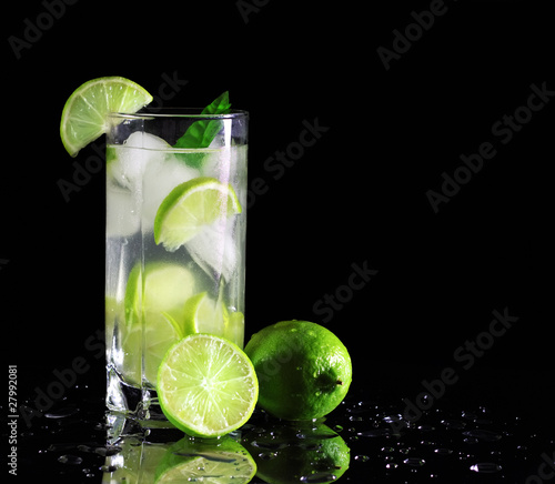 Photo: Mojito cocktail with fresh limes on a black background Mojito cocktail with fresh limes on a black background