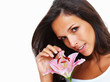 Brunette holding stargazer lily while looking into camera Brunette holding stargazer lily while looking into camera