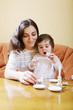 Smiling mummy playing with daughter