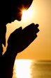 Silhouette of woman which sits near  sea opposite  sun and laid