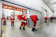 Photo: santa clauses leaving a gift distribution center with red sacks santa clauses leaving a gift distribution center with red sacks