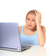 Junge Frau sitzt erschöpft vor ihrem Computer