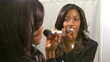 Young woman putting on makeup