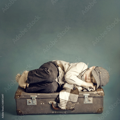 Photo: boy sleeping on a suitcase boy sleeping on a suitcase