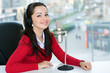 A woman DJ is in front of a mic in the broadcasting studio A woman DJ is in front of a mic in the broadcasting studio