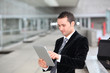 Foto: Salesman stading oustide with electronic tablet Salesman stading oustide with electronic tablet