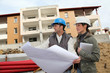 Architect and engineer looking at plan on construction site Architect and engineer looking at plan on construction site