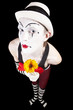 .Funny mime in white hat with a bouquet of flowers