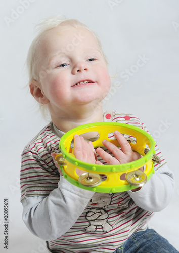 Photo: isolated portait baby playing tamborine isolated portait baby playing tamborine