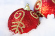 rote Christbaumkugeln im Schnee